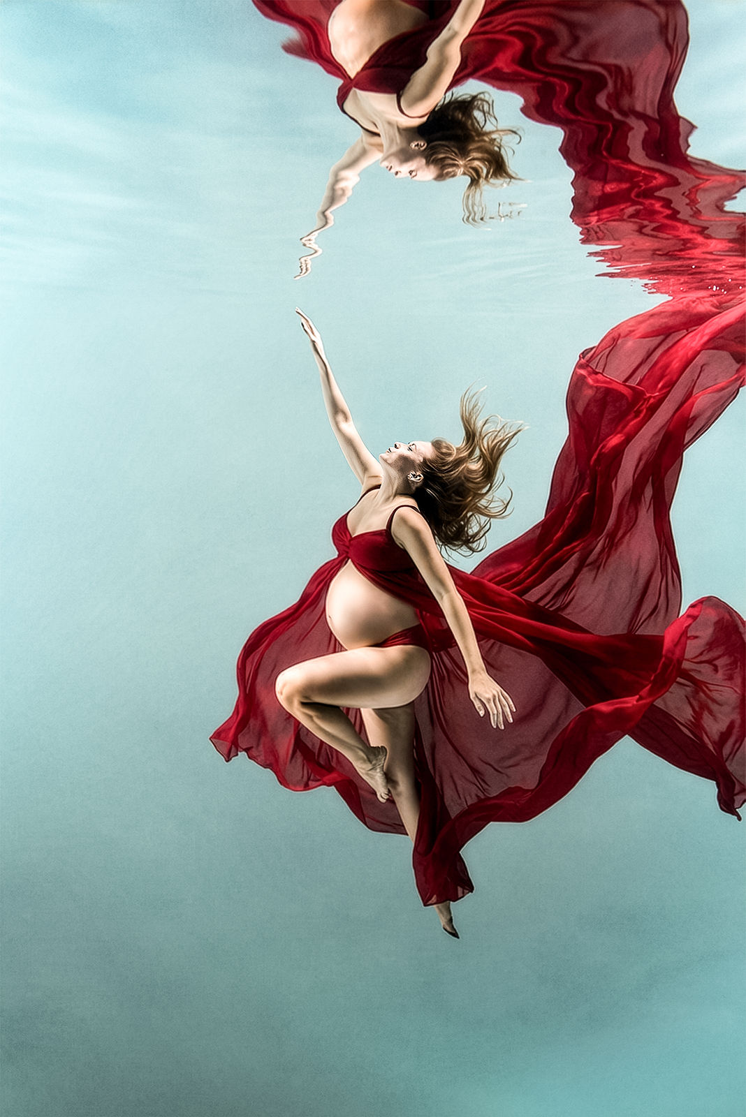 Künstlerisches Unterwasserportrait mit rotem Kleid